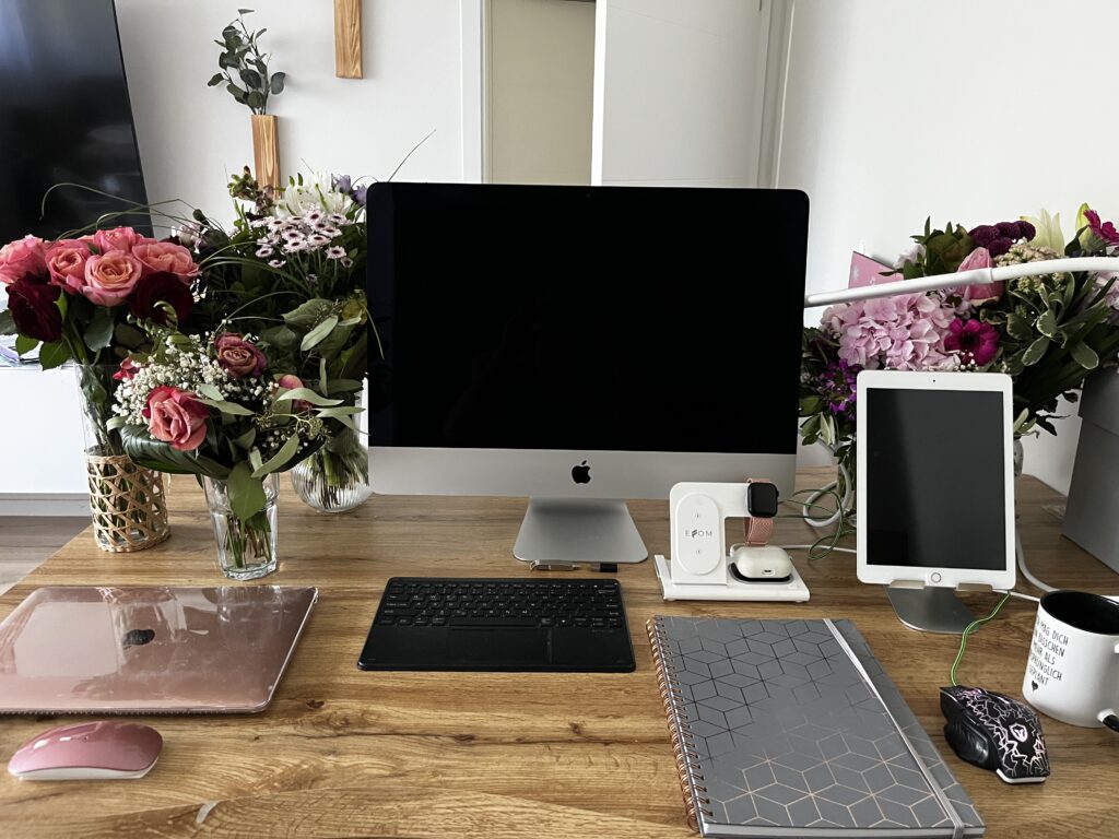 iMac auf einem Holztisch Büroausstattung, Blumen drumherum